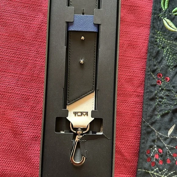 New in box Tumi leather strap- never removed from box - box has small damage
